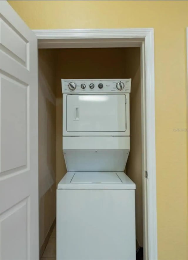 washroom featuring stacked washing maching and dryer