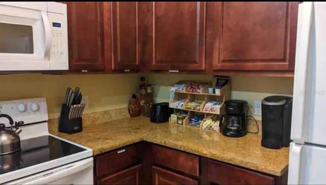 kitchen with light stone counters and white appliances