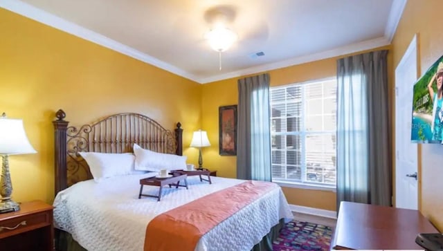 bedroom with ceiling fan and crown molding