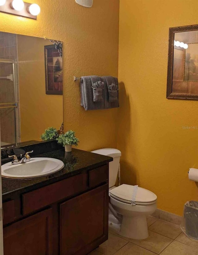 bathroom featuring tile patterned flooring, toilet, and vanity