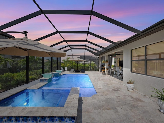 view of pool featuring an in ground hot tub, ceiling fan, pool water feature, a patio area, and glass enclosure