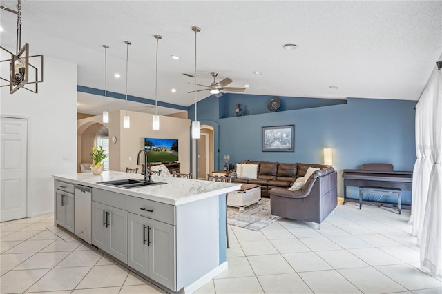 kitchen with arched walkways, hanging light fixtures, open floor plan, a kitchen island with sink, and dishwasher