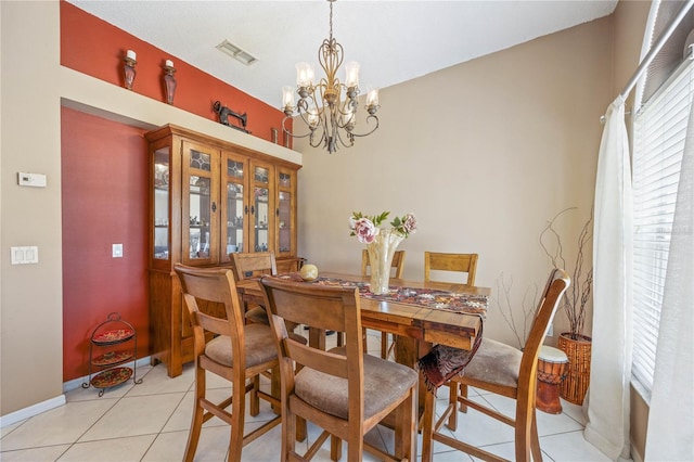 dining space featuring light tile patterned floors, baseboards, visible vents, and a notable chandelier