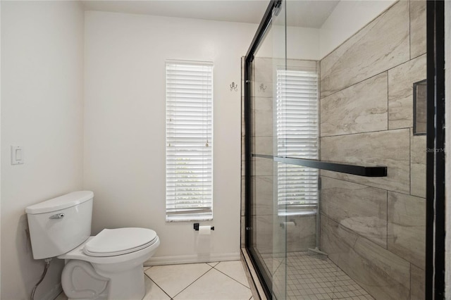 bathroom with a stall shower, toilet, and tile patterned floors