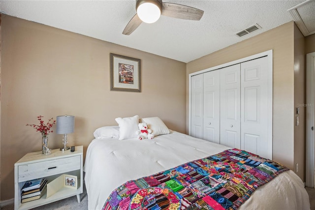 bedroom with a ceiling fan, a closet, visible vents, and a textured ceiling