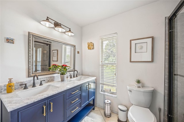 bathroom with toilet, double vanity, a sink, and tile patterned floors