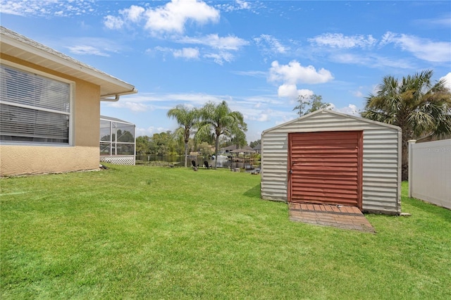 view of yard featuring glass enclosure, an outdoor structure, a storage shed, and fence