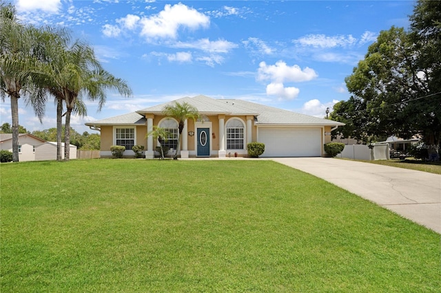 ranch-style home featuring driveway, a garage, fence, a front yard, and stucco siding