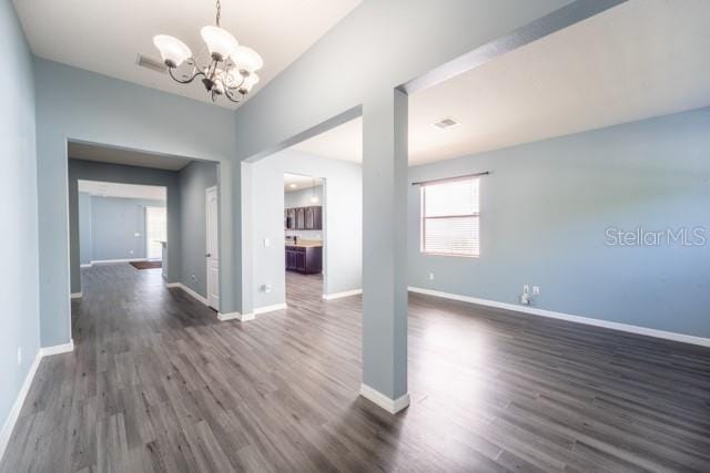 interior space with dark wood-type flooring and a chandelier