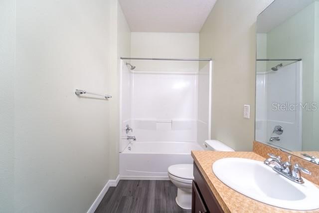 full bathroom featuring shower / bath combination, vanity, wood-type flooring, and toilet