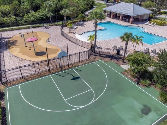 view of basketball court with a community pool