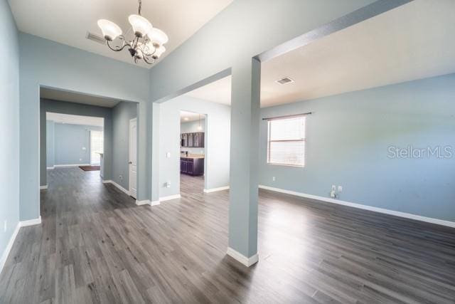 interior space with dark wood-type flooring and an inviting chandelier