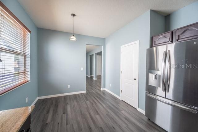 kitchen with dark hardwood / wood-style flooring, dark brown cabinetry, stainless steel refrigerator with ice dispenser, and hanging light fixtures