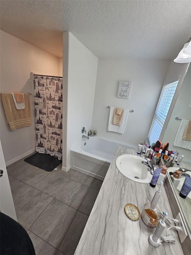 bathroom with a textured ceiling, tile patterned flooring, and vanity