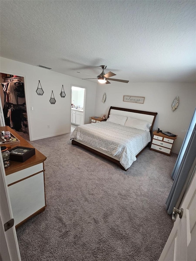 bedroom featuring a walk in closet, carpet flooring, a closet, and ceiling fan