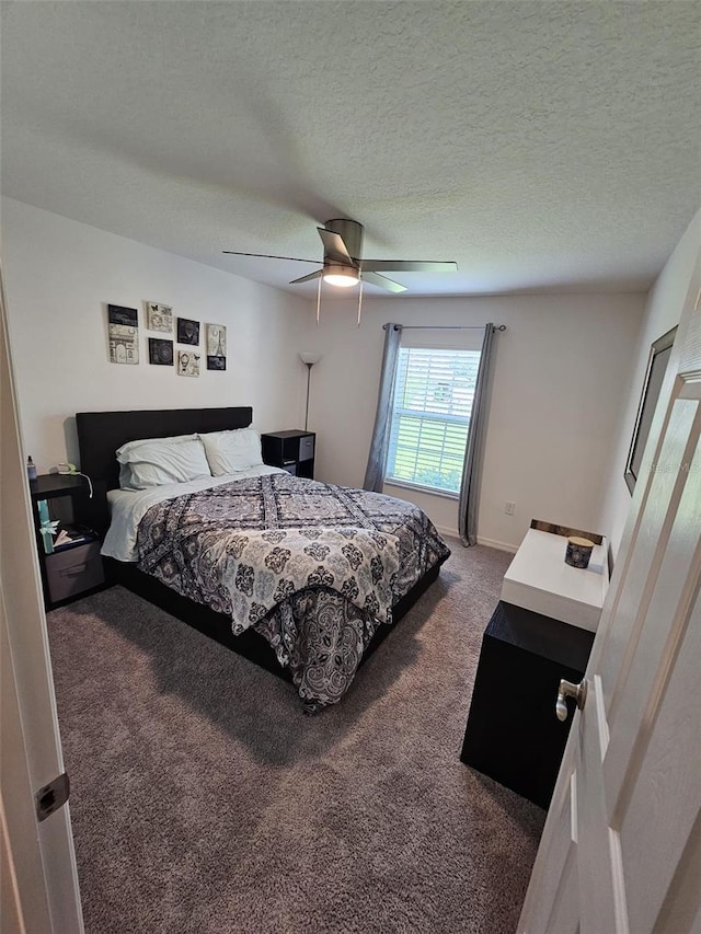 carpeted bedroom featuring ceiling fan and a textured ceiling