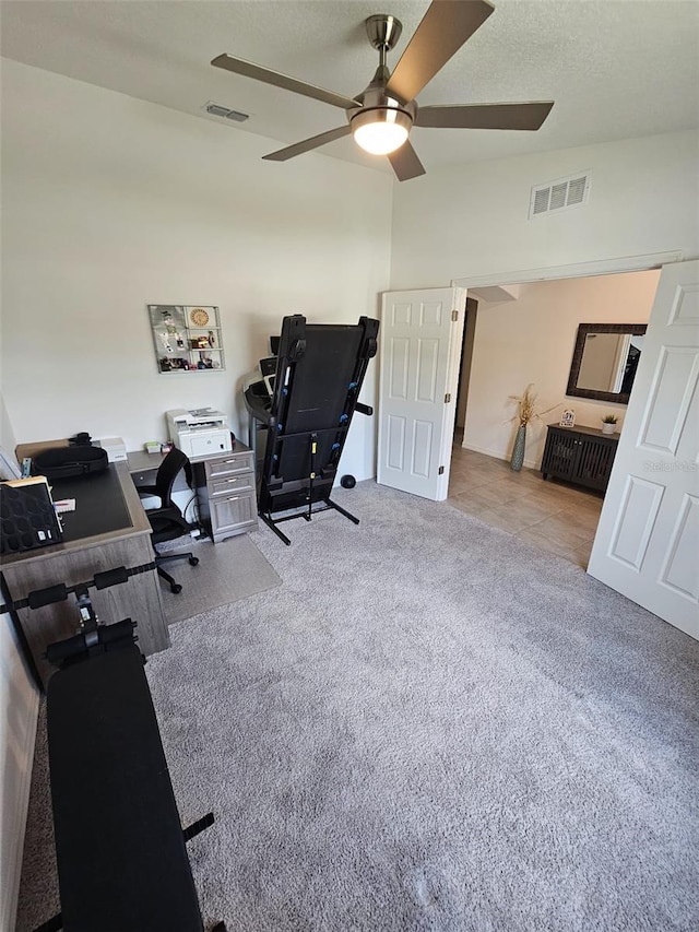 carpeted home office featuring ceiling fan