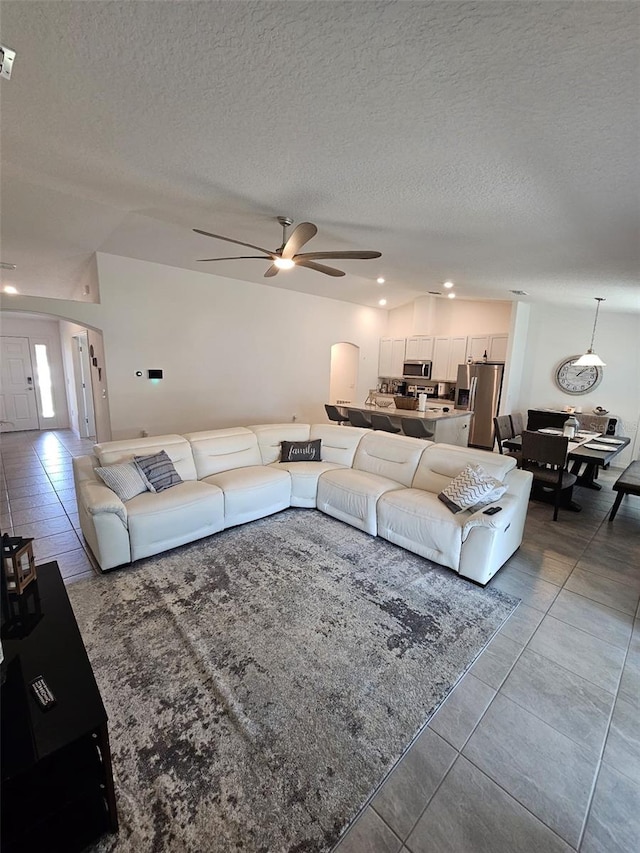 tiled living room featuring ceiling fan and a textured ceiling