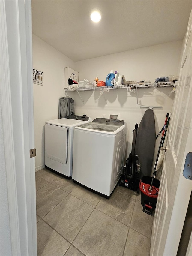 washroom featuring light tile patterned floors and washer and clothes dryer