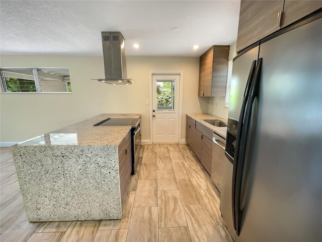 kitchen featuring sink, stainless steel appliances, light stone counters, and island range hood