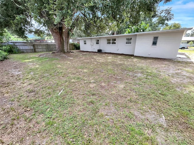 back of property with cooling unit and a lawn