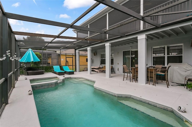 view of pool with glass enclosure, an in ground hot tub, and a patio