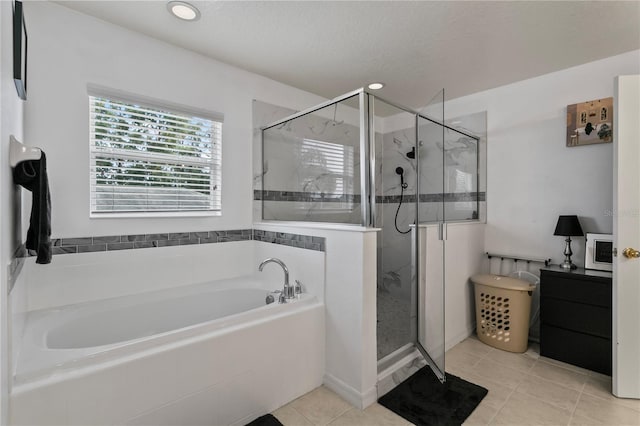 bathroom featuring tile patterned flooring and shower with separate bathtub