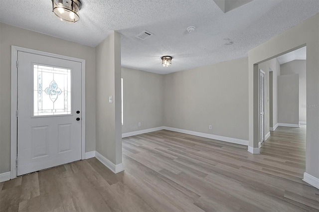 foyer featuring light hardwood / wood-style floors and a textured ceiling