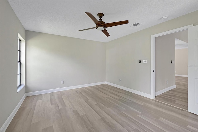 spare room featuring light hardwood / wood-style flooring, a textured ceiling, and ceiling fan