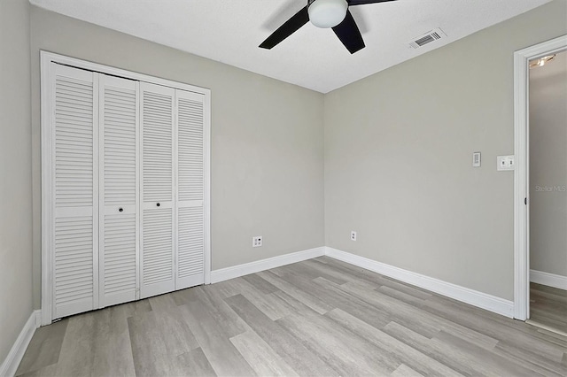 unfurnished bedroom featuring a closet, ceiling fan, and light wood-type flooring