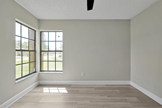 empty room featuring a textured ceiling and light wood-type flooring