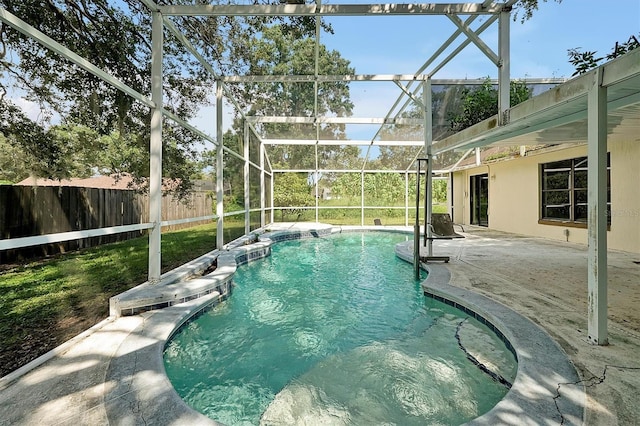 view of swimming pool featuring a hot tub, a patio area, and glass enclosure