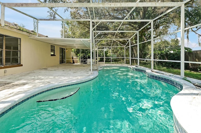 view of swimming pool featuring a patio area and a lanai