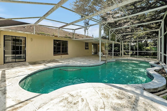 view of swimming pool with a patio area and a lanai