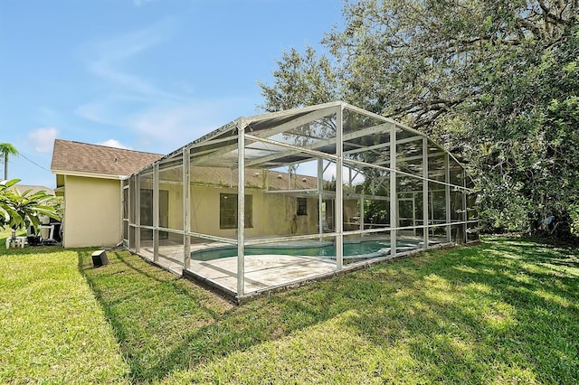 back of house featuring a lawn and glass enclosure