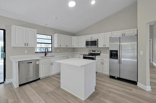 kitchen with a kitchen island, light hardwood / wood-style flooring, stainless steel appliances, sink, and white cabinets