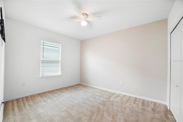 unfurnished bedroom with a closet, ceiling fan, and light colored carpet