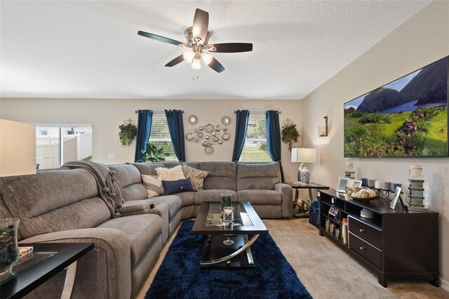 living room featuring a textured ceiling, ceiling fan, and light carpet