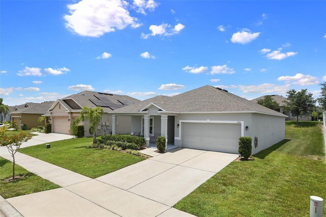 view of front facade featuring solar panels, a garage, and a front lawn