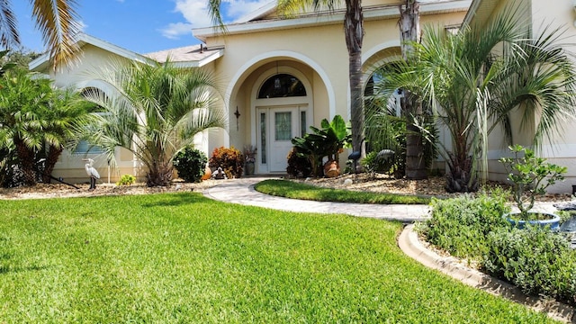 view of front facade with a front yard and stucco siding