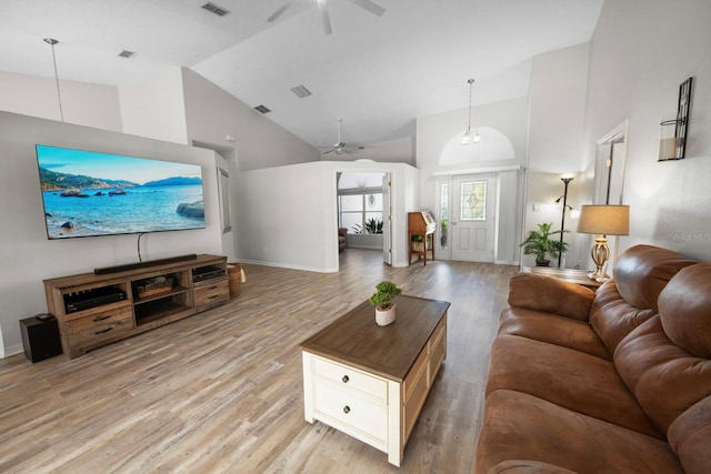 living room with ceiling fan, high vaulted ceiling, and light hardwood / wood-style flooring