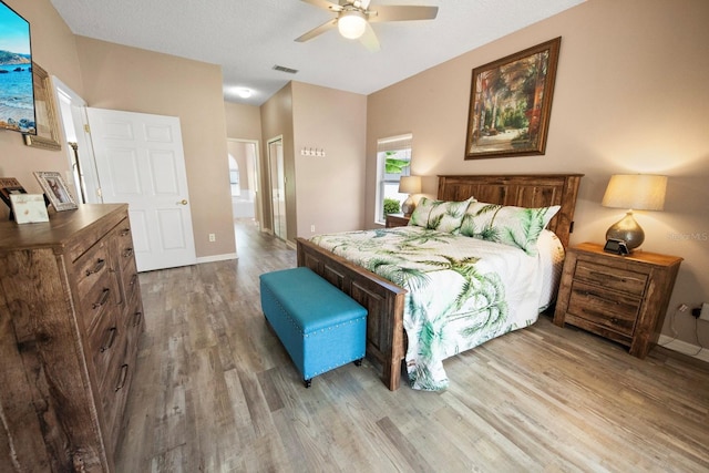 bedroom with ceiling fan, wood finished floors, visible vents, and baseboards