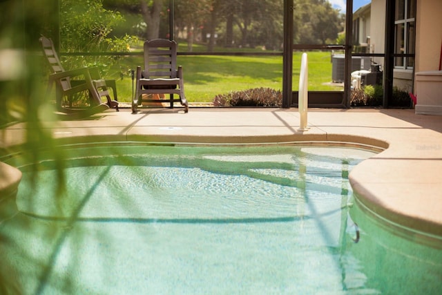 view of swimming pool with cooling unit, a patio area, and a yard