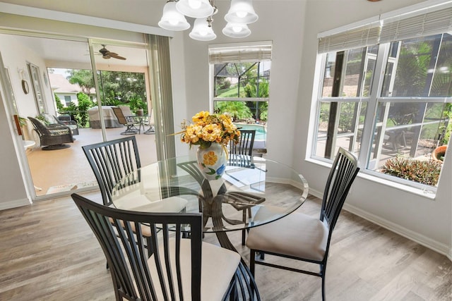 dining space with light hardwood / wood-style floors and an inviting chandelier