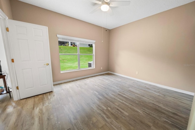 spare room with ceiling fan, wood finished floors, and baseboards