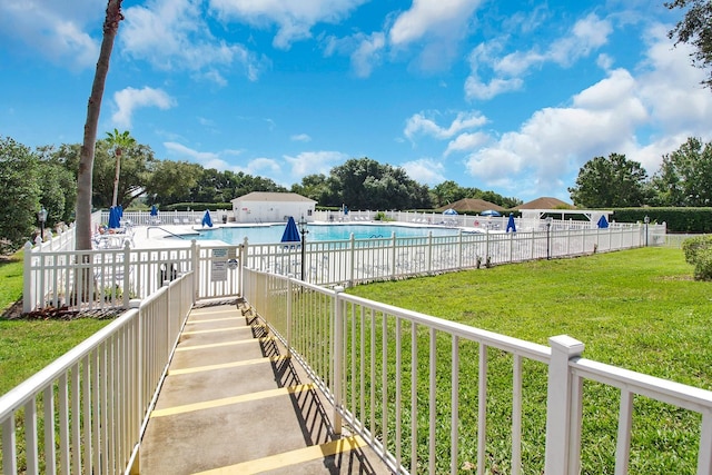 view of swimming pool featuring a yard