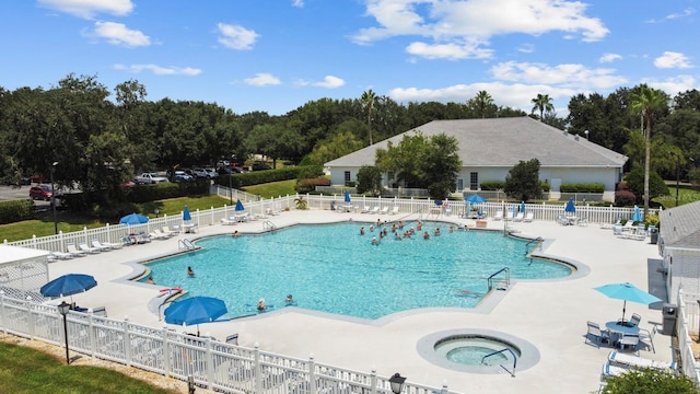 pool featuring a community hot tub, a patio area, and fence