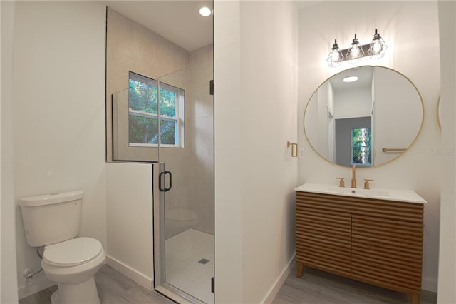 bathroom featuring vanity, toilet, hardwood / wood-style flooring, and an enclosed shower