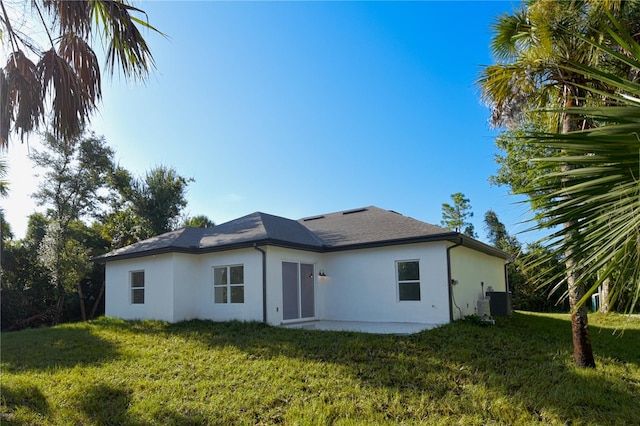 rear view of property with a yard, a patio area, and central AC unit