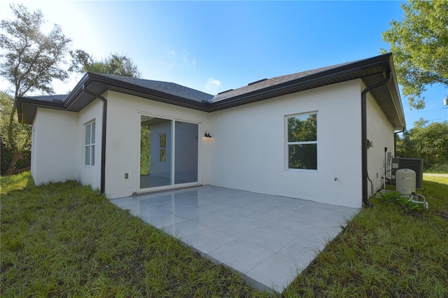 back of property with a lawn and a patio area